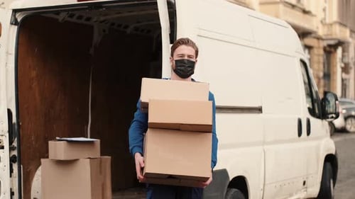 Blue Delivery Handsome Man Holding Parcel Cardboard Boxes with Protection Mask