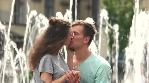 Romantic Young Couple Kissing by Water Fountain