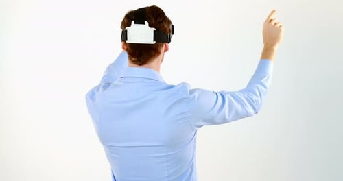 Mann gestikuliert bei Verwendung eines Virtual-Reality-Headsets vor weißem Hintergrund