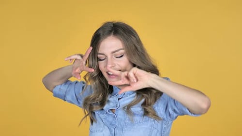 Happy Woman Dancing in Front of Yellow Background