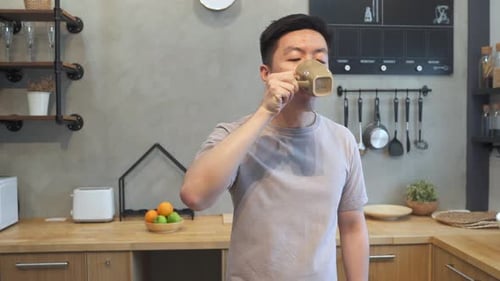 Young Adult Man Drinking and Eating an Apple