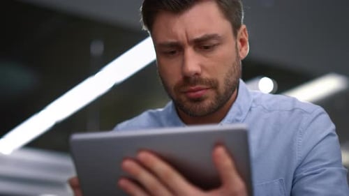 Handsome Businessman Working Tablet Researching Corporate Software in Office