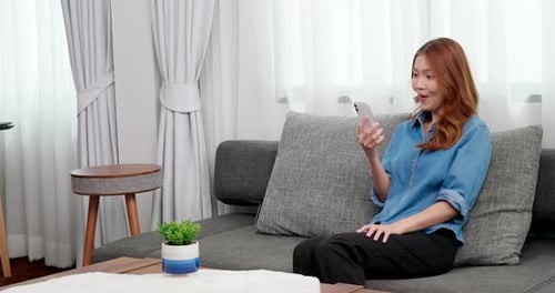 Woman Video Calling on Sofa Looking Happy