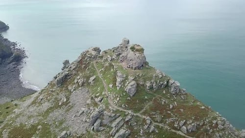 Rotating aerial of the cliff stack at the Valley of Rocks in Exmoor, Devon. Person walking down the