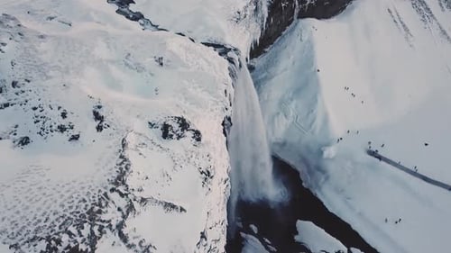 Weite Luftaufnahme zeigt den Seljalandsfoss-Wasserfall im Winter in Island