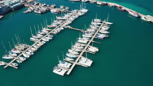 Flying Over Fishing Boats on a Pier and a Small Boat on Water