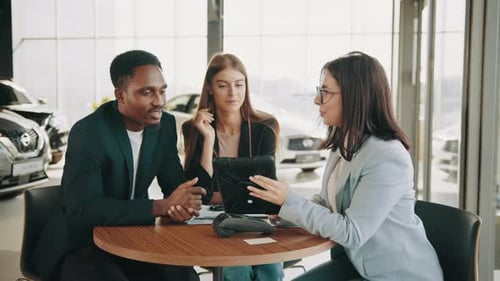 Couple Consults with Car Saleswoman at Dealership