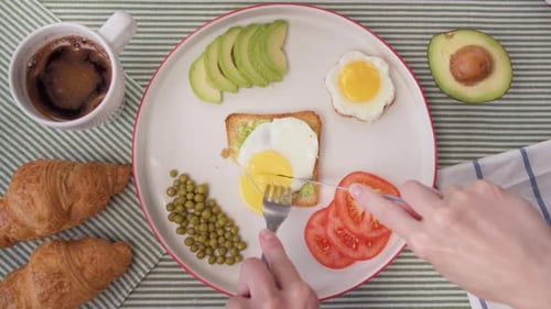 Top View Women's Hands Cut Toast with Egg