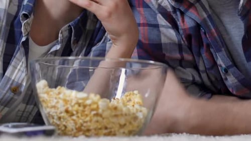 Father and Son Share Popcorn at Home