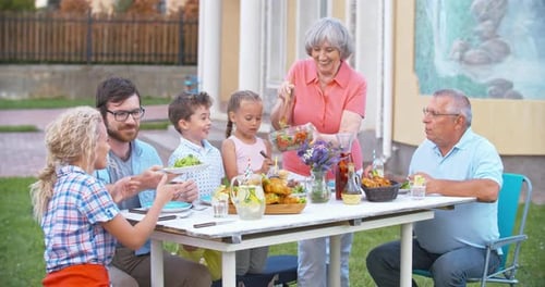 Family Enjoying Outdoor Meal Together on Sunny Day