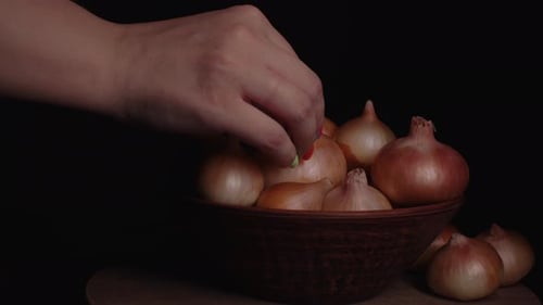 Pile of Whole Bulbs of Raw Onion in Ceramic Bowl on Table
