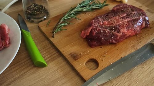 Close Up of Raw Steak with Seasoning and Rosemary