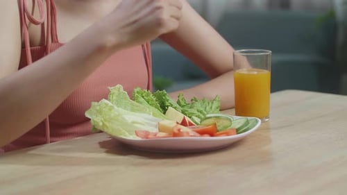 Woman Eating a Healthy Salad at Table