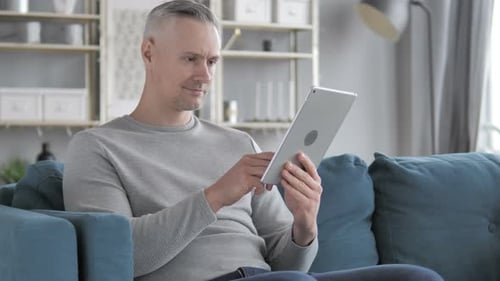 Man Using Tablet Device in Living Room