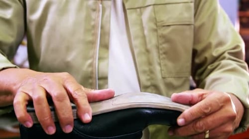 Man Repairing Leather Shoe in Workshop