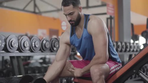 Konzentrierter Sportler hebt Hantelgewichte im Fitnessstudio