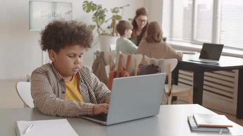 Junge gemischter Rassen benutzt Laptop im Klassenzimmer