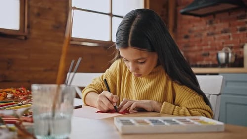 Child Girl Circling Orange Leaf Laying on White Sheet of Paper with Black Felttip Pen