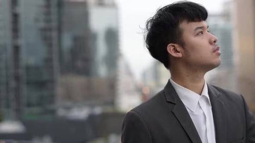 Portrait of Young Asian Businessman Against View of the City