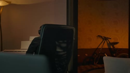 Man Talking with Headphones at Computer at Night