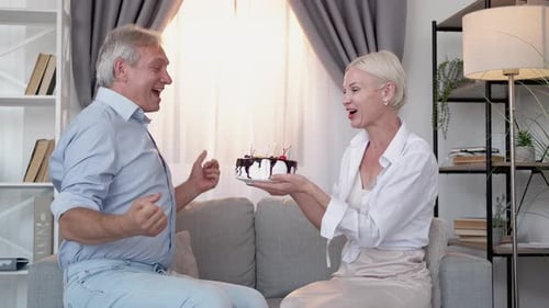 Senior Couple Celebrates Birthday with Cake at Home