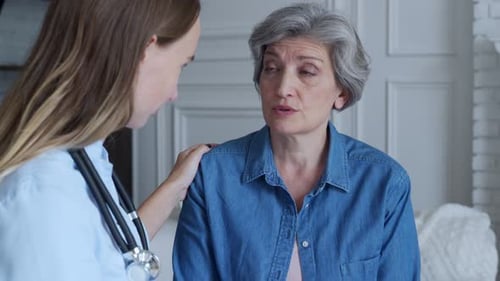 Doctor Talking To a Elderly Woman Patient at Medical Office in Hospital. Healthcare and People