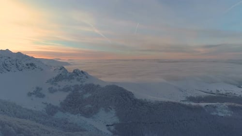 Red cloud sunset over frozen forest and winter landscape