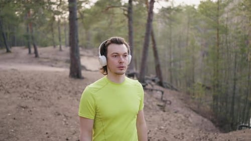 Man Walking in Forest with Headphones