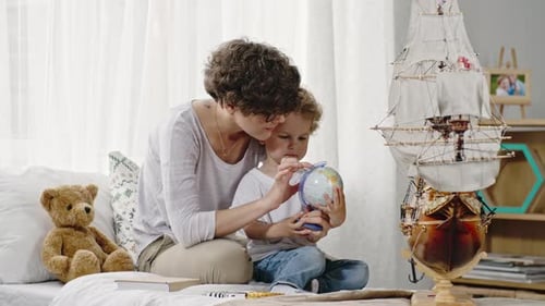 Mother and Child Learning with Globe Indoors