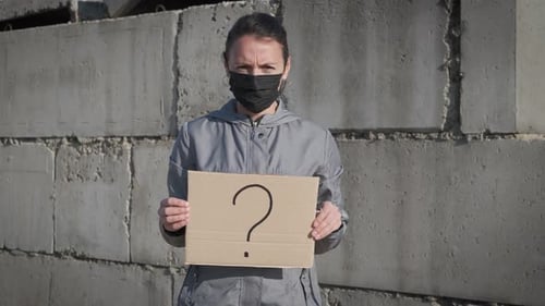 Adult Holding Question Mark Cardboard Sign