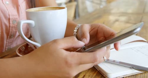 Teenager-Mädchen benutzt Handy im Restaurant