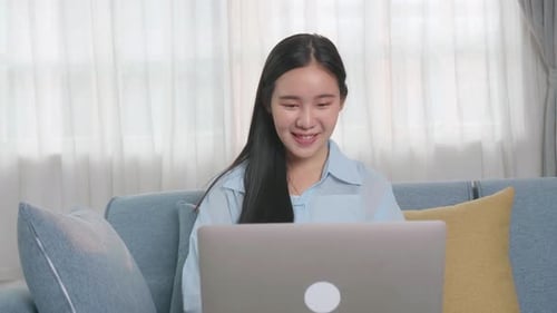Smiling Woman Working on Laptop at Home