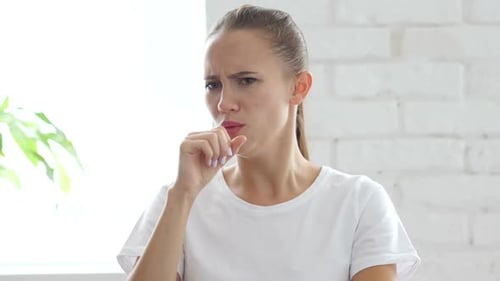 Young Woman Coughing indoors