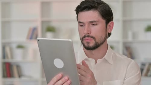 Young Man Using a Tablet Device Indoors