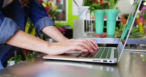 Woman Typing on Laptop in Flower Shop