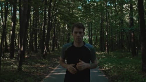 Athletic Young Man Trains for Marathon Run in Park