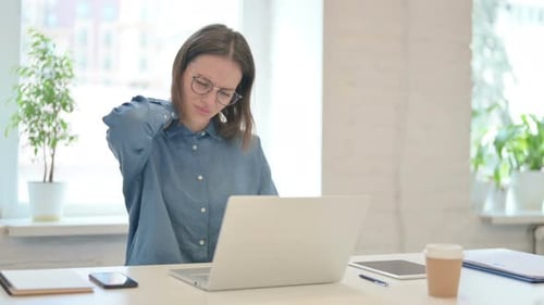 Young Woman with Neck Pain Working at Laptop