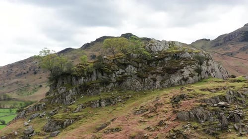 Aerial View Over Hills Towards Mountains