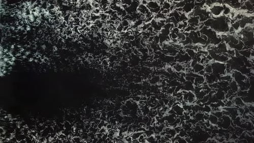 Stunning Aerial Footage of Waves Breaking Against Beautiful Black Sand Beach