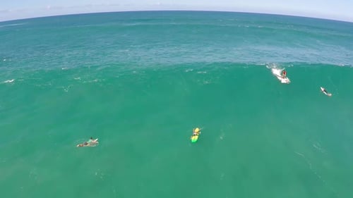 Aerial view of a man sup stand-up paddleboard surfing in Hawaii
