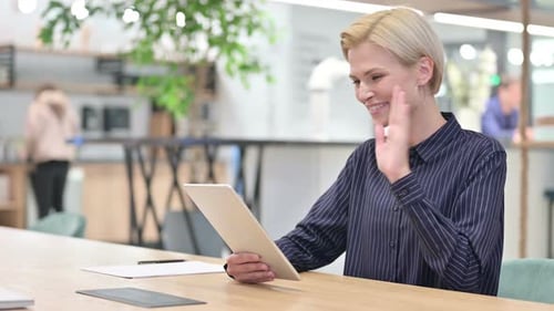 Cheerful Businesswoman Doing Video Chat on Digital Tablet in Office
