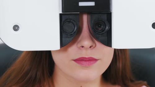 Junge Frau überprüft ihre Sehschärfe mit einer speziellen Optometrie