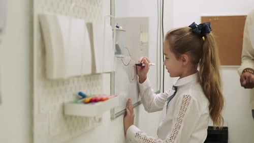 Girl Child Pupil Draws on the Chalkboard While Learning