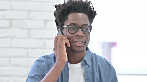 Young Man Answering a Smartphone Call