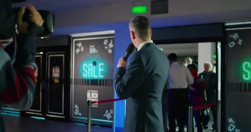 Man Speaking into Microphone at Black Friday Event