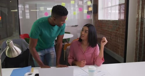 Man and Woman Discussing Work in Modern Office