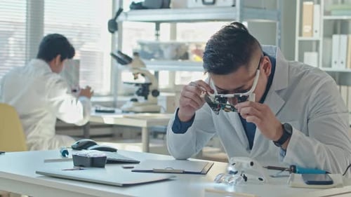 Male Engineer Inspecting Circuit Board in Laboratory
