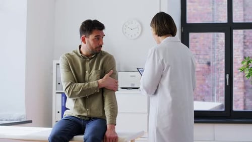 Man Patient Showing Sore Arm to Doctor at Hospital