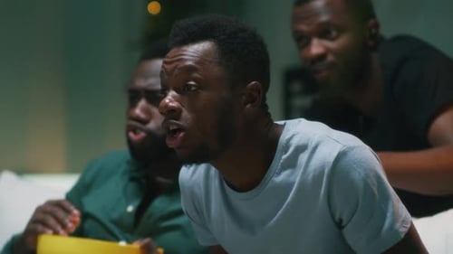 Excited Friends Cheer While Watching Sports at Home