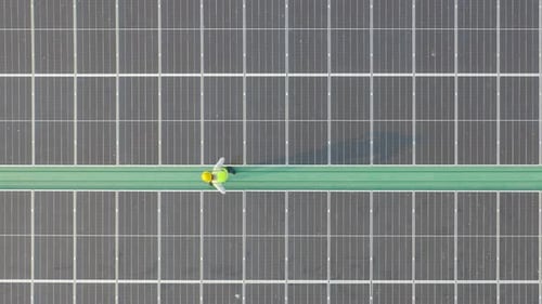 Aerial top view of engineer man or worker,people, with solar panels or solar cells on the roof